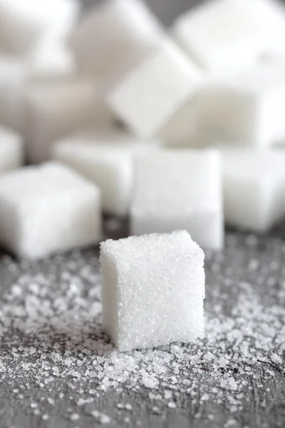 Sockerbitar på grå bord — Stockfoto