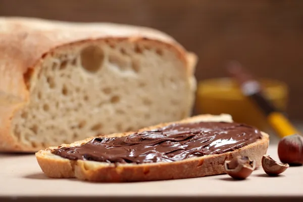 BREAD WITH NUTELLA ON WOODEN TABLE — Stock Photo, Image