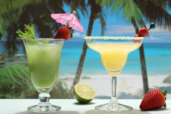 Alcoholhoudende cocktails met fruit op het strand — Stockfoto