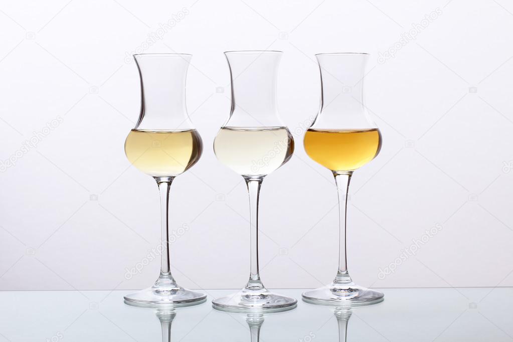 cocktails three glass with tequila or rum or grappa on gray background