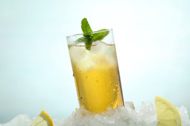 yeşil zemin üzerine bir bardak buz ve limon ile çay