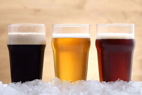Birra tre bicchieri con lager birra rossa e nera sul ghiaccio — Foto Stock
