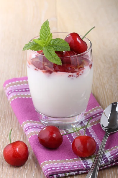 Diario de yogur de postre con cereza en una copa sobre una mesa de madera — Foto de Stock