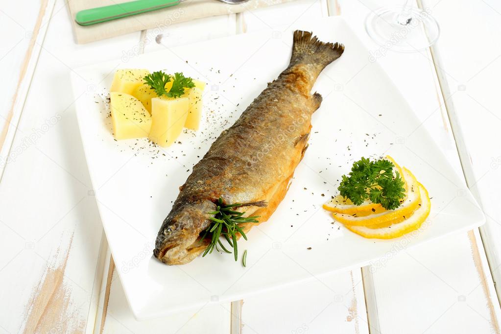 Fried fish on white ceramic plate