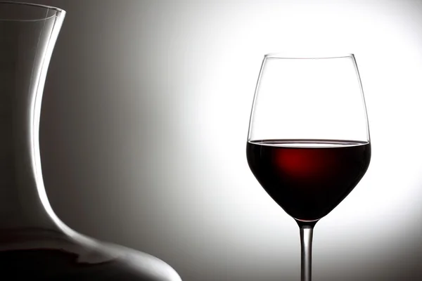 Vino rosso in un punto di vetro illuminazione sfondo grigio — Foto Stock