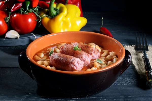 Sausages and beans in ceramic pan — Stock Photo, Image