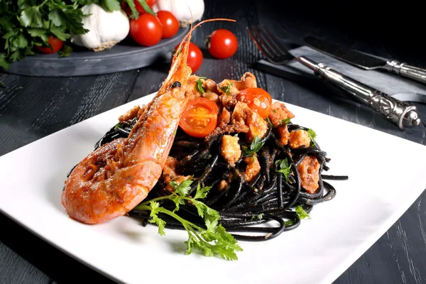 Esparguete de macarrão preto com fundo escuro de frutos do mar — Fotografia de Stock