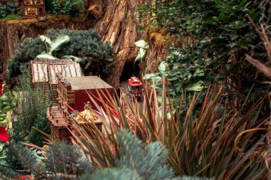 Doğal malzemelerden oluşan bir trenle tünelden çıkan bir model tren.