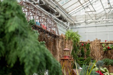 Seradaki çubuklardan yapılmış bir köprüden geçen model tren.