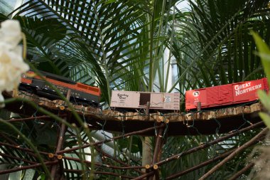 Bahçedeki bir köprüde model tren.