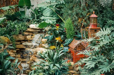 Tatil bahçesinde deniz feneri ve şelale