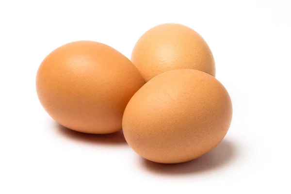Beyaz bir arka plan üzerinde izole kahverengi üç yumurta — Stok fotoğraf