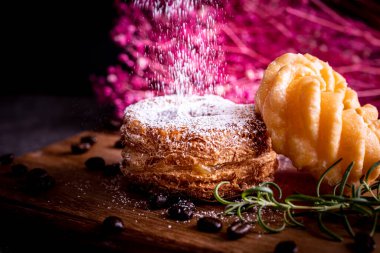 Kesme tahtasının üzerinde iki tane şık ve lezzetli çörek.