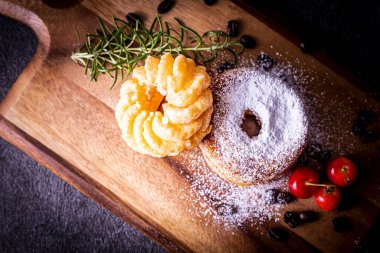 Kesme tahtasının üzerinde iki tane şık ve lezzetli çörek.