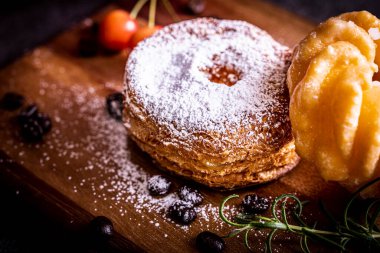 Kesme tahtasının üzerinde iki tane şık ve lezzetli çörek.