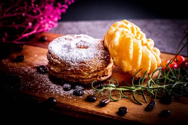 Kesme tahtasının üzerinde iki tane şık ve lezzetli çörek.