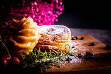 Kesme tahtasının üzerinde iki tane şık ve lezzetli çörek.