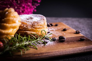Kesme tahtasının üzerinde iki tane şık ve lezzetli çörek.