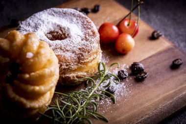 Kesme tahtasının üzerinde iki tane şık ve lezzetli çörek.