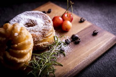 Kesme tahtasının üzerinde iki tane şık ve lezzetli çörek.