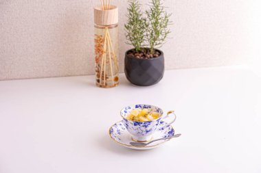 Lezzetli peynirli kek ve çay fincanında yapılmış kivi meyvesi.