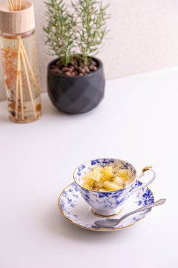 Lezzetli peynirli kek ve çay fincanında yapılmış kivi meyvesi.