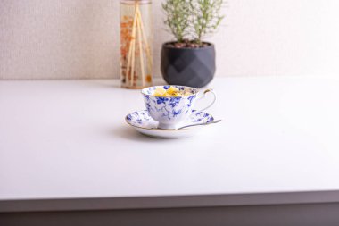 Lezzetli peynirli kek ve çay fincanında yapılmış kivi meyvesi.