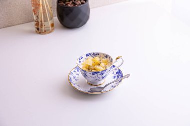 Lezzetli peynirli kek ve çay fincanında yapılmış kivi meyvesi.