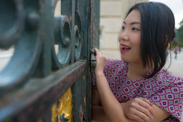아름다운 아시아인 아름다운 드레스를 마드리드 관광을 즐기고 철문에서 느긋하고 — 스톡 사진