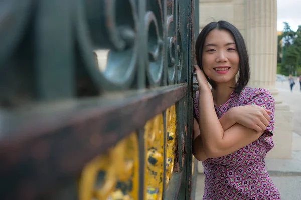아름다운 아시아인 아름다운 드레스를 마드리드 관광을 즐기고 철문에서 느긋하고 — 스톡 사진