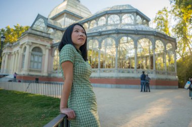 Genç, mutlu ve çekici Asyalı kadının hayat tarzı portresi, sonbahar tatilleri sırasında İspanya 'da şehir parkında yürüyüş yaparken rahatladı ve seyahatin tadını çıkardı.