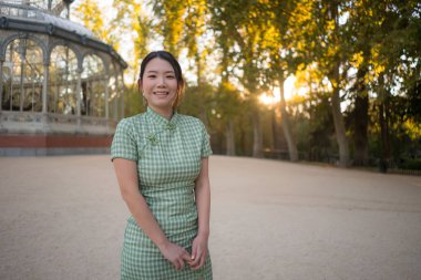 Genç, mutlu ve çekici Asyalı kadının hayat tarzı portresi, sonbahar tatilleri sırasında İspanya 'da şehir parkında yürüyüş yaparken rahatladı ve seyahatin tadını çıkardı.
