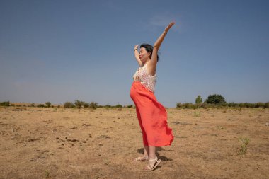 outdoors lifestyle portrait of young happy and beautiful Korean woman enjoying summer holiday while pregnant proud of her belly as mother expecting baby concept