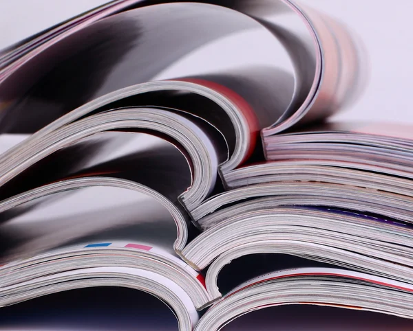 Closeup background of a pile of old magazines with bending pages — Stock Photo, Image