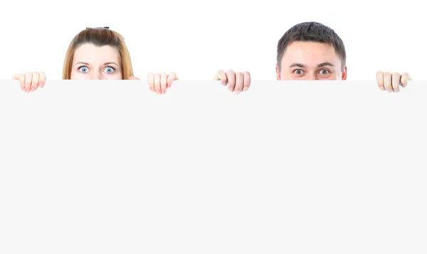 Hombre y mujer escondidos detrás de un espacio de copia sobre un fondo blanco —  Fotos de Stock