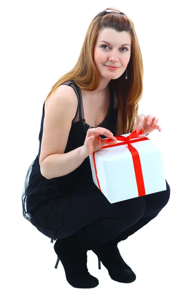 La belle fille souriante tient un cadeau dans une boîte sur un fond blanc — Photo