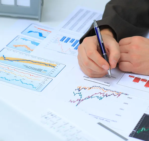 Empresario analizando gráficos de inversión en su lugar de trabajo — Foto de Stock