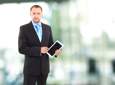 Onun ofisinde bir tablet bilgisayar kullanarak bir genç ofis çalışanı portresi