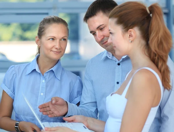 Retrato del equipo de negocios discutiendo mientras miran juntos el portátil — Foto de Stock