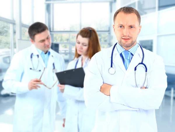 Retrato médico sorrindo com colegas de fundo — Fotografia de Stock