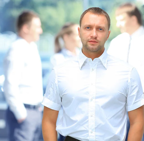 Guapo hombre de negocios feliz con colegas en la parte posterior — Foto de Stock