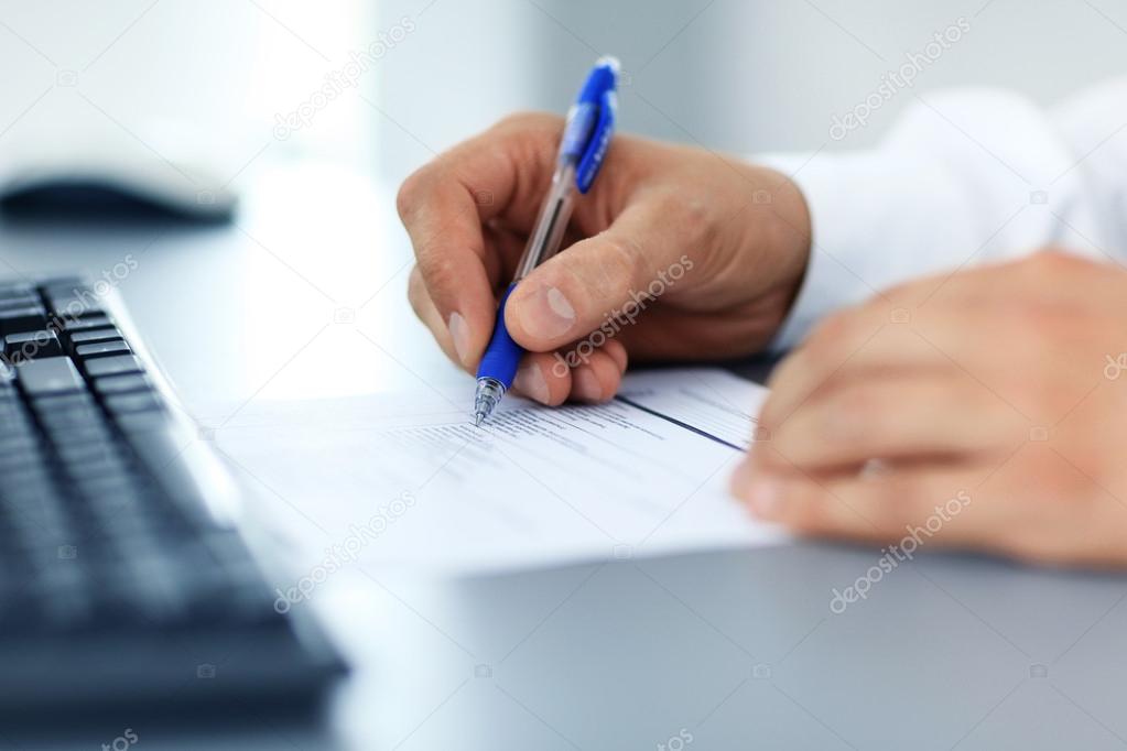 Hands writing on a paper