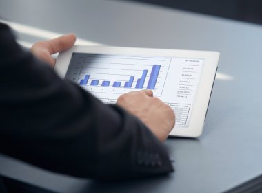 busienssman dijital tablet ofisinde tutuyor.