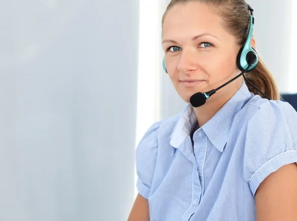 Operadora de suporte ao cliente feminina com fone de ouvido e sorrindo — Fotografia de Stock