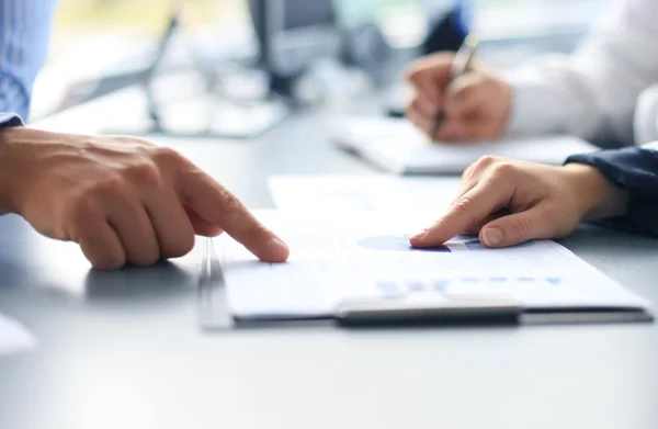 Unrecognizable business person analyzing graphs and taking notes — Stock Photo, Image