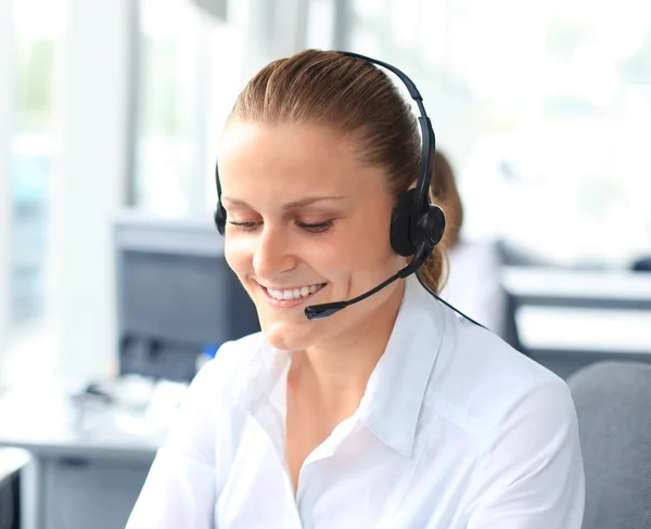 Jovem operadora de call center bonita com fone de ouvido no escritório — Fotografia de Stock