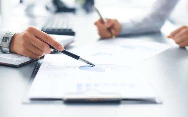 Unrecognizable business person analyzing graphs and taking notes — Stock Photo, Image