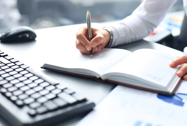 Zakenvrouw maakt een notitie in notebook — Stockfoto