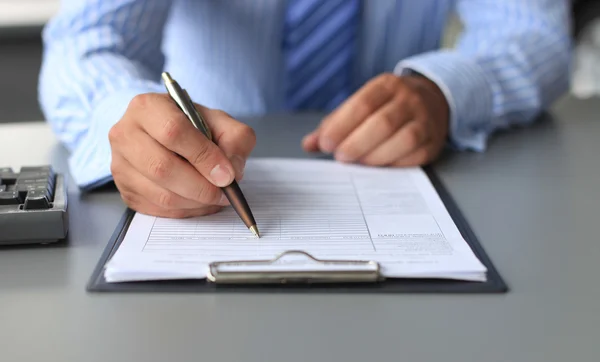 Businessman sitting at office desk signing a contract Stock Image