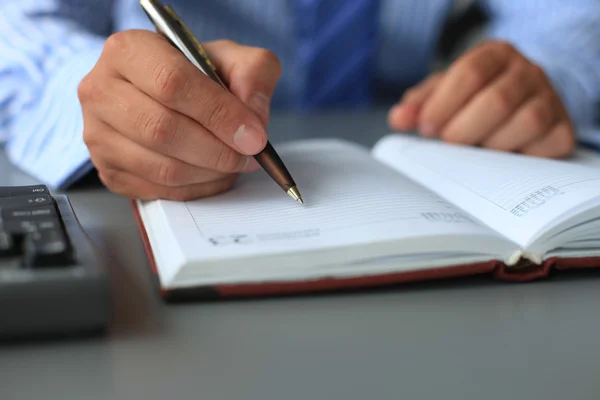 Businessman makes a note in notebook — Stock Photo, Image